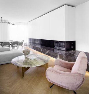 The fireplace is surrounded by a marble bench that runs the length of the living and dining room.
