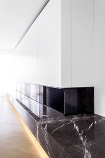 A custom unit around the fireplace conceals cabinets and shelves.