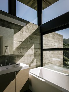 Retirement Never Looked Better and More Sustainable - Photo 7 of 10 - The bathroom in the guest pavilion takes advantage of the passive solar siting. "Detaching the roof from the walls allowed us to bring in light from the top," notes the architect. The custom vanity holds a Lacava sink; the tub is AquaStone from Aquatica.