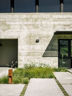 Retirement Never Looked Better and More Sustainable - Photo 8 of 10 - More native grasses set the tone near the generously sized concrete pavers leading to the entrance. "We didn’t want the planting to feel like a country cottage garden—that would have felt disconnected with the view behind it," Trainor says.