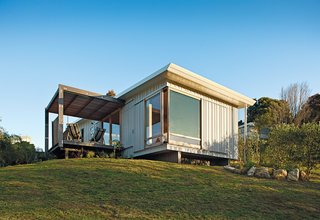 Students Pass Their Class by Building a House in New Zealand - Photo 1 of 7 - A compact prefab vacation home in the seaside community of Onemana Beach is clad in plywood and vertical timber battens finished in Resene’s Lumbersider paint in Foam.