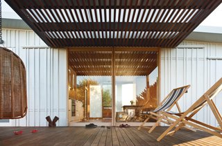 Students Pass Their Class by Building a House in New Zealand - Photo 3 of 7 - Sliding glass doors made from Viridian’s ComfortPlus glass and yellow cedar wood lead to decks flanking the kitchen and dining room.