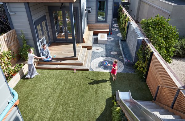 A pebble mosaic and artificial turf divide the yard into zones that never need to be mowed.  