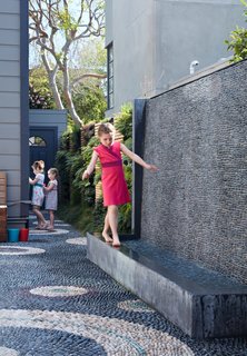 The water wall was one of the family’s main requests. Not only does it provide the girls— Serafina, Carolina, and Madeleine—a place to play, it also blocks street noise. 