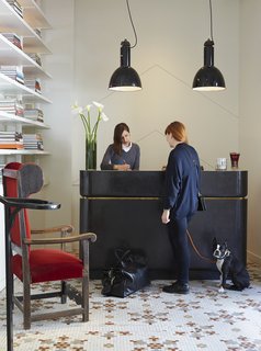 This Boutique Hotel Loves its City Like No Other - Photo 3 of 14 - In the lobby, guests are greeted at a reception desk fabricated by NYC company FERRER and illuminated by vintage pendants sourced from Belgium. The ornate tile on the floor is original—a nod to the building's past.