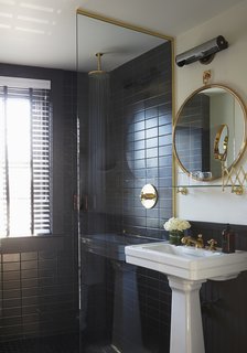 This Boutique Hotel Loves its City Like No Other - Photo 13 of 14 - The bathrooms are clad in black Daltile and feature brass hardware from Watermark in the European-style shower and on the sink. The mirror is custom. ASH worked with American Medicinal Arts on the custom-scented toiletries. 