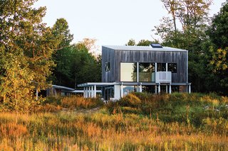 A Lakeside Home Brings a Scandinavian Sensibility to the Midwest - Photo 4 of 6 - Brogan’s home overlooking Lake Michigan is clad in tongue-and-groove new-growth cypress. Vertical basswood slats follow the stairs to the second floor and into the master bedroom, extending outside to serve as the railing for a small balcony.