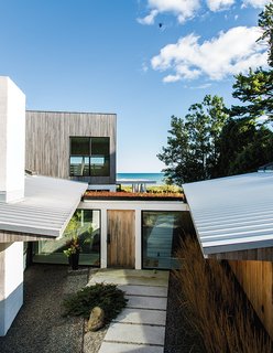 A Lakeside Home Brings a Scandinavian Sensibility to the Midwest - Photo 6 of 6 - A glass-framed corridor crosses a central courtyard to connect these spaces with the main house.