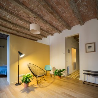 In Barcelona, Vaulted Ceilings Are Always a Win - Photo 4 of 5 - The partition separating the bedroom from the living room appears to be a partial wall—but in reality, a mirror extends from the top of the wall to the ceiling. 