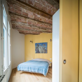 In Barcelona, Vaulted Ceilings Are Always a Win - Photo 5 of 5 - The apartment, approximately 765 square feet in total, contains one master bedroom as well as a smaller sleeping space for guests. A sliding door closes off the bedroom from the living area when total privacy is desired. 