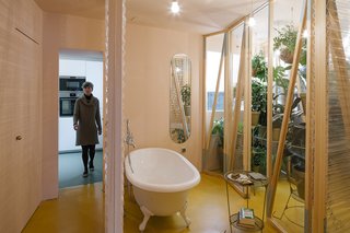 A Quirky Renovation Brings an Indoor Garden to the Center of Madrid - Photo 5 of 6 - The bathroom is located at the heart of the apartment, with sliding plastic doors of varying transparency that can be moved into a number configurations.