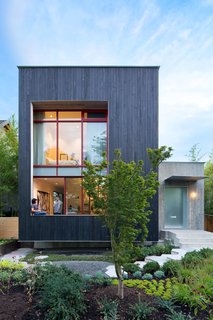 A Wild Garden Leaps Off the Walls of This Backyard Build - Photo 4 of 4 - The street-facing facade leans into the landscape with a three-foot-deep cantilever and toward a pathway of hexagonal concrete pavers. 