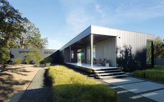 When Prefab Is Painless - Photo 1 of 7 - When Abbie and Bill Burton hired Marmol Radziner to design their prefab weekend home, their two requests were "simple-simple, replaceable materials," says Abbie—such as concrete floors (poured offsite in Marmol Radziner's factory) and metal panel siding—and "the ability to be indoors or outdoors with ease." Deep overhangs provide shade and protection from rain, so the Burtons can leave their doors open year-round and hang out on their 70-foot-long deck even in inclement weather. They visit the house once a month, usually for a week at a time, with Vinnie and Stella, their rescue Bernese Mountain dogs. Their two adult children occasionally join them. The couple hopes to one day retire here.