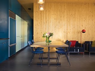 This High-Flying Home Tackles a Sharp Slope - Photo 7 of 8 - Eames Wire Chairs, cushioned with custom pads, surround a dining table designed by Bolander.