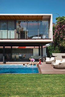 On an idyllic afternoon, members of the Oropeza and Castillo clans splash in the backyard pool framed by Trex decking and outfitted with furniture by Móbica. 