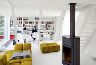 This Minimal Addition Looks Magical in the Belgian Forest - Photo 3 of 4 - In the living area, a Tufty-Time sofa by Patricia Urquiola for B&B Italia, a Soft Grid blanket by Established & Sons, and a wood-burning stove by Stûv keep her comfortable. 