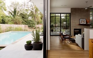 A double-sided fireplace serves as a way to unite the screened-in porch to the house’s main, open-plan living area.