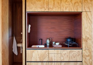 The other structure, lined in plywood, recalls the simplicity of New Zealand’s traditional bachs, or seaside cabins. Oiled jarrah eucalyptus clads the kitchen alcove. In the bathroom, Vola’s Arne Jacobsen tapware joins an Architec basin by Duravit.