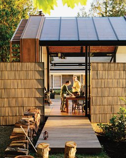 To reference the original structure and to offer privacy, Grizzle left two of the shingled walls standing. The building, accessed by a cedar deck, opens to its surroundings via a sliding glass wall by Fleetwood and a bifold steel-and-glass garage door from Wilson Doors.