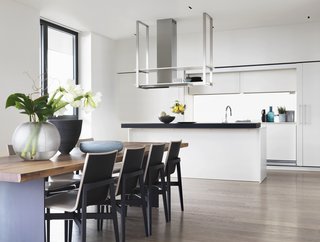 Pretty on the Inside: The Luxe Residences of Milan's Vertical Forest - Photo 4 of 6 - Soothing hues ranging from white to gray pair with warm woods throughout the residence. The dining area feature Who chairs by Rodolfo Dordoni for Molteni&C. 