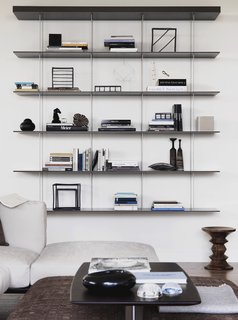 Pretty on the Inside: The Luxe Residences of Milan's Vertical Forest - Photo 6 of 6 - The sitting area features Jean Nouvel's Graduate shelf for Molteni&C and walnut stool by Charles and Ray Eames.