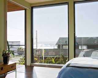 Rising Tides Are No Match for This Coastal Home - Photo 5 of 10 - Floor-to-ceiling windows in the bedroom create the sensation of being outside, as if the entire house is one platform deck strategically shielded from the elements. 
