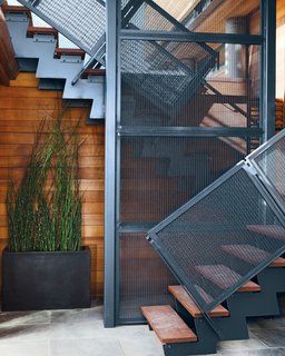 Rising Tides Are No Match for This Coastal Home - Photo 8 of 10 - The steel stairwell that connects the garden-level patio with the new living space performs double duty as an anchor attached to the foundation. 