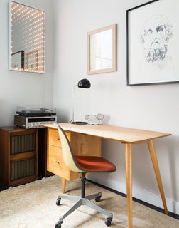 725 Square Feet and Loads of Modern Gems - Photo 4 of 6 - In the office, a 1950s desk by Paul McCobb is complemented by an Eames chair and the Boi desk lamp by David Weeks Studio. The lighted mirror is a piece called "Through the Looking Glass" by Earl Reiback.