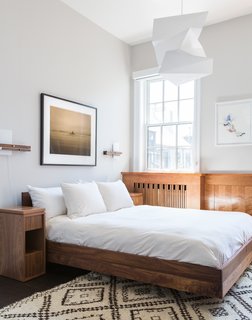 725 Square Feet and Loads of Modern Gems - Photo 5 of 6 - The Simple Hi bed by Formstelle defines the bedroom, which also features a custom nightstand by Reddymade Design, Levo sconces by Cerno, a vintage Moroccan rug, and an Isamu Noguchi pendant.