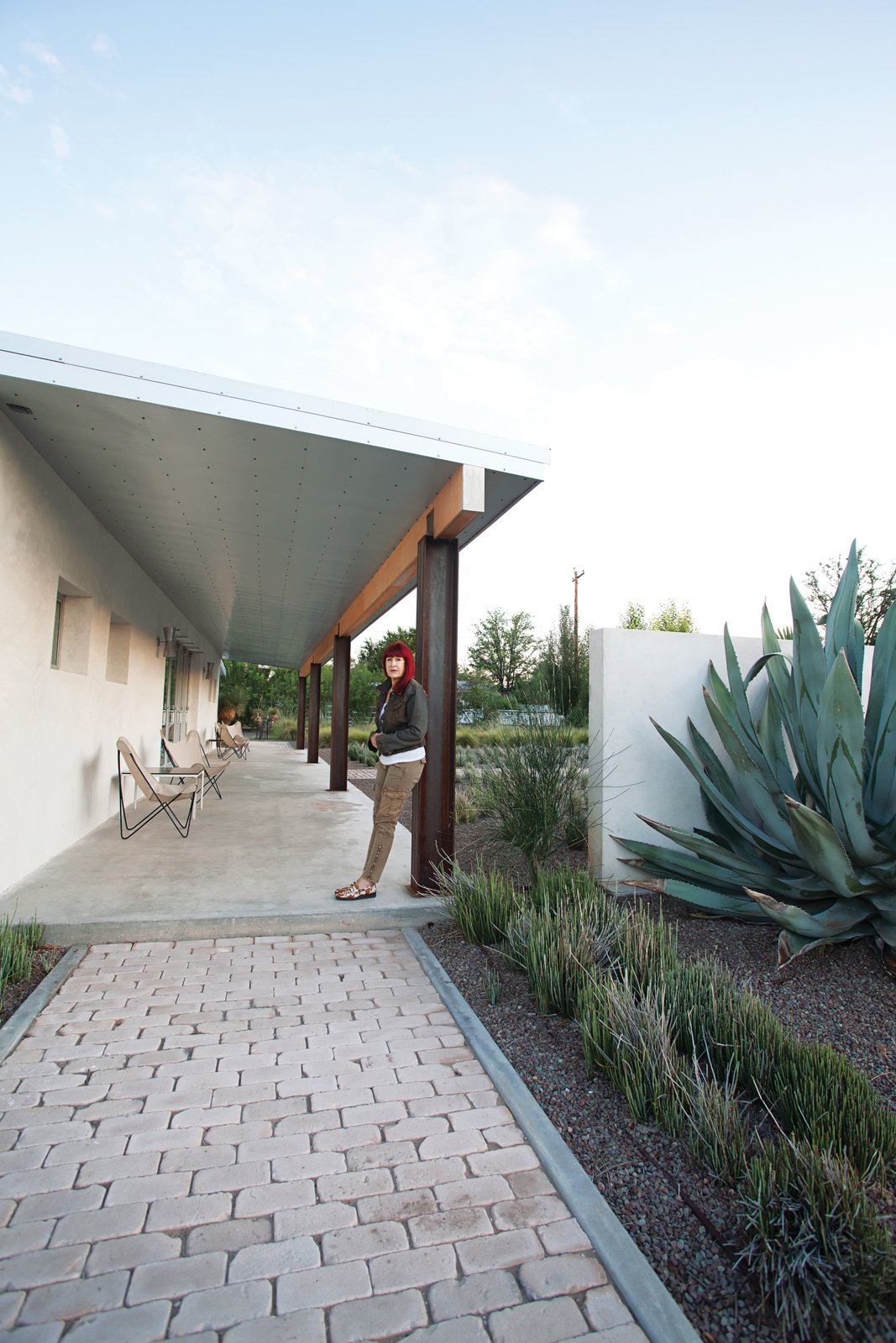 Designer Barbara Hill, in front of her recently renovated weekend house in Marfa, Texas. A series of Galvalume roofing panels clad the underside of the eaves.