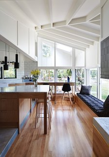 This Kitchen Brings It All Together - Photo 3 of 4 - The architects used blackbutt wood for the flooring and Whisper White paint by Dulux throughout the interior. An A110 Hand Grenade Pendant Lamp, by Alvar Aalto for Artek, hangs above the white Carrara marble-topped island.