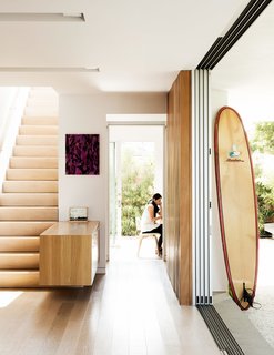 Amid a Hotbed of Architecture, This Home Holds Its Own - Photo 1 of 9 - Tracy O’Brien sits in her renovated bungalow in Venice, California, where a multi-slide panel door by Fleetwood Aluminum opens up to what she and her husband, Thaddeus Stauber, refer to as their "outdoor living room." Inveterate art collectors, the couple own several works, including a Paul Heyer painting and a framed piece by Shana Lutker displayed near the staircase. 