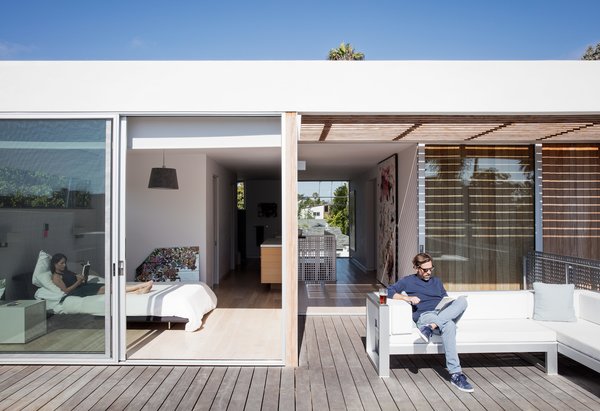 Amid a Hotbed of Architecture, This Home Holds Its Own - Photo 4 of 9 - Tracy and Thaddeus enjoy an afternoon read from the master bedroom and terrace, respectively; the outdoor sectional is by Gandia Blasco. 