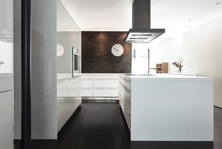 The kitchen features cabinets from Bulthaup’s B3 line and a hearth made of ironspot brick. Evans and his wife, Susan Wilson, bought the wall clock at Habitat in London. 