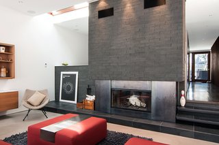 A slight gap between the existing house and the new addition allows for a skylight and a masonry chimney with a wood-burning fireplace. 