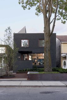 The transformed facade features dark gray stained-masonry. 