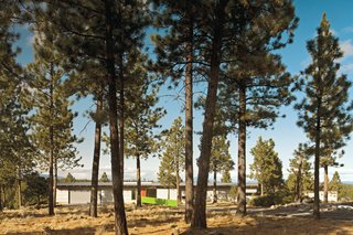 The front facade, covered in Minerit HD fiber cement panels, is muted save for a bright-green entrance ramp and red door. The entire project came in at about $225 per square foot. 