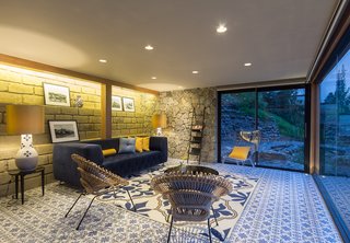 The interior is defined by material combinations that are as entrancing as the view. Ceramic tile flooring pairs with local stone walls in the living room. 