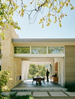 A Meadow With Amenities - Photo 5 of 10 - The dining area features sliding glass doors by Fleetwood. Interior designer Toni Ambus paired a reclaimed sycamore table by Dekayu with Lea dining chairs by Roberto Barbieri for Zanotta. A Broom pendant by Brand van Egmond lights the room.