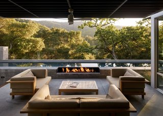 A Meadow With Amenities - Photo 7 of 10 - Concealed speakers from James Loudspeaker, scattered throughout the indoor and outdoor rooms, let the residents stream music from their phones. A trio of love seats and a coffee table from Henry Hall’s Tru/Pure collection form another outdoor room. 