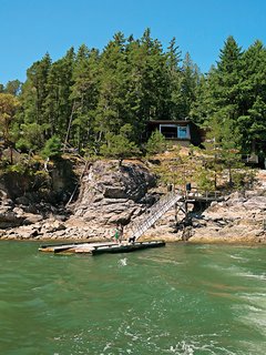 The architects designed every gesture of the home as a complement to the landscape, including the slot windows that frame views of the surrounding foliage and the walkway that follows the bedrock of the cliff. 
