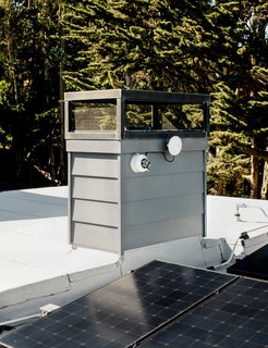 A Hikvision video camera on the roof (top right) streams a live feed of the city to a television on a windowless wall inside. 