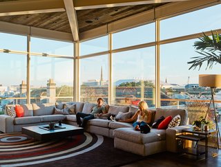 High Above Traditional Charleston, a Modern Home Finds its Roost - Photo 4 of 7 - Rich and his girlfriend Arielle sit on an IKEA sofa; the windows are from Charleston Glass. 
