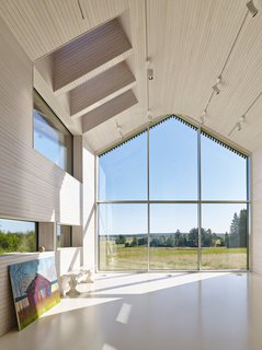 This Battery-Powered House Never Runs Out of Juice - Photo 2 of 7 - Elina works beneath a series of skylights and LED spots from Zumtobel in her studio. <span style="line-height: 1.8;">At more than 16 feet tall, the locally fabricated windows benefit from aluminum frames, which can be substantially thinner than wood versions.</span>