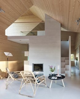 This Battery-Powered House Never Runs Out of Juice - Photo 4 of 7 - The living room includes a table from Normann Copenhagen, chairs by Annansilmät-Aitta, and Alvar Aalto’s A810 lamp for Artek, all on a poured concrete floor.