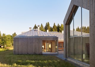 This Battery-Powered House Never Runs Out of Juice - Photo 5 of 7 - The home comprises three structures: a main house, a garage, and a studio for resident Elina Försti, an artist. Local spruce cladding, metal standing-seam roofs, and aluminum frames mean the entire complex is recyclable. "Right now, it all looks very polished, but in the future it will develop a nice patina," Lassila says. 