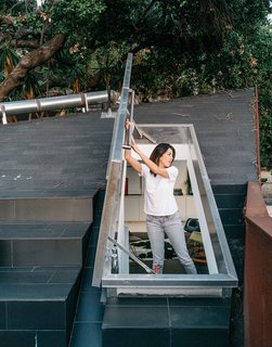 This Los Angeles Home is Driven by Automotive Design - Photo 7 of 9 - Kristine climbs out onto the concrete-tile roof deck through a hatch door in the upstairs loft. 