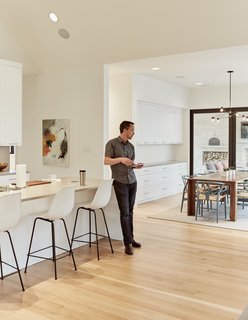 Automation Eliminates Tedious Chores for Dallas Homeowners - Photo 5 of 6 - A set of Eames molded-plastic bar stools line the Caesarstone countertop in the kitchen. 