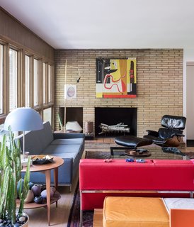 American Beauty - Photo 2 of 8 - In the living room, a vintage Paul McCobb sofa, a Gio Ponti side table, and an Eames lounge echo the home’s midcentury architecture—as does the thrifted red Florence Knoll Parallel Bar sofa that lends the room a shot of color.