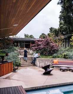 Once unkempt terrain, the lot was replanted by Elysian Landscapes. Board-formed concrete walls now hold a lush collection of Bloodgood Japanese maple trees, Canyon Prince wild rye grasses, and Blue Fox Tail agaves. A Spun stool by Heatherwick Studio for Magis joins an outdoor furniture set by Plain Air.